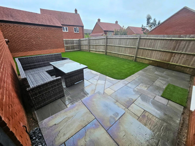 artificial grass and paving installed. low maintenance patio design.