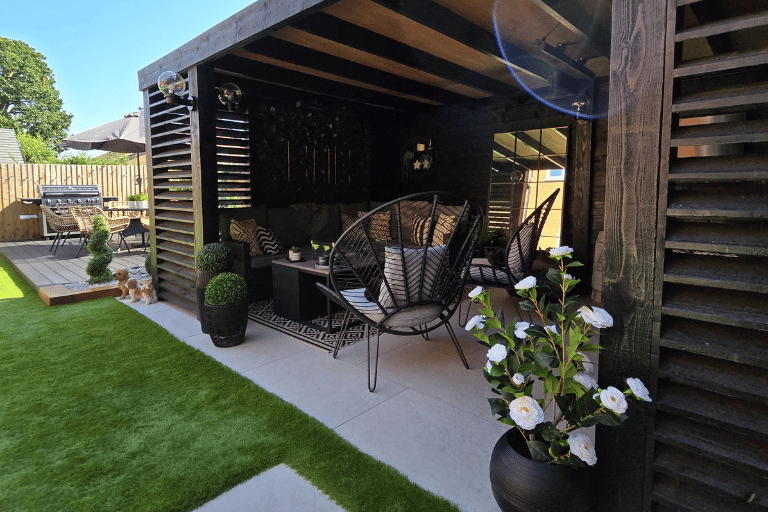 Modern garden lounge area with artificial grass and stylish covered seating.